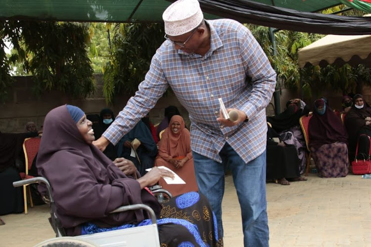 Garissa Township MP Aden Duale presents a Sh200,000 cheque to Dhahabo Abdi Ali of Ayan Women's Group on Tuesday.