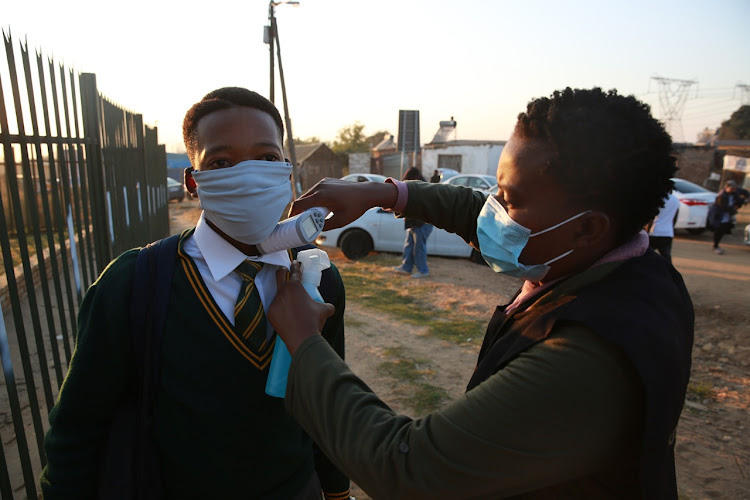 Learners at Olivenhoutbosch secondary school queue as their tempreture levels are screened before they enter the school premises in June 8 2020.