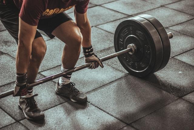 A man bending ready to do his lifting routine