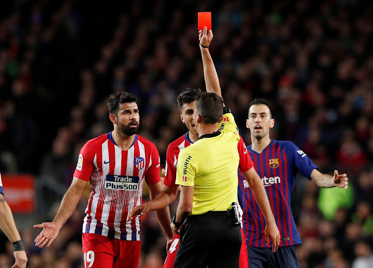 Atletico Madrid's Diego Costa is shown a red card by referee Jesus Gil Manzano