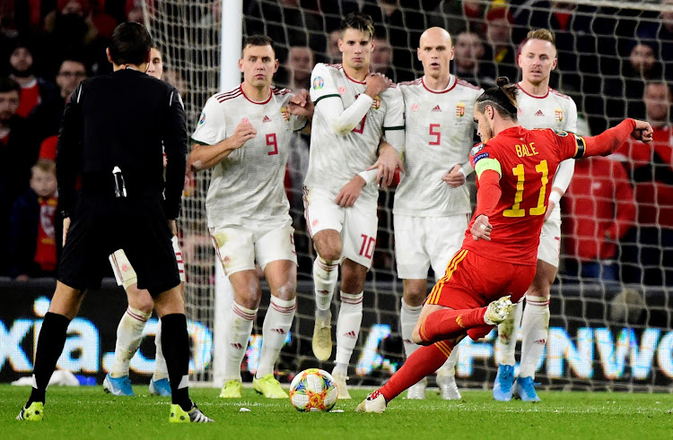 Wales' Gareth Bale shoots at goal from a free kick against Hungary