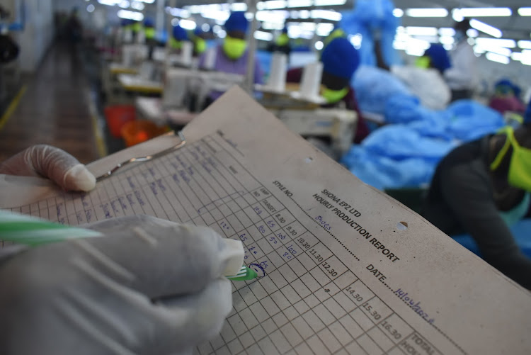 A supervisor follows on production of PPEs and face masks