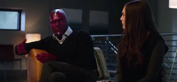 Vision wearing normal clothing. A V-neck sweater over a collared shirt and slacks.