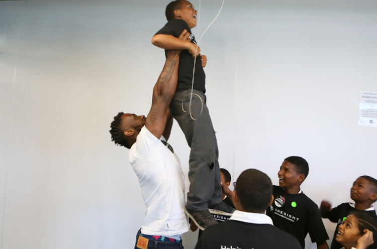 Siya Kolisi plays with children after his foundation and OneSight EssilorLuxottica provided free eye exams and glasses to youngsters from under-resourced communities. File image