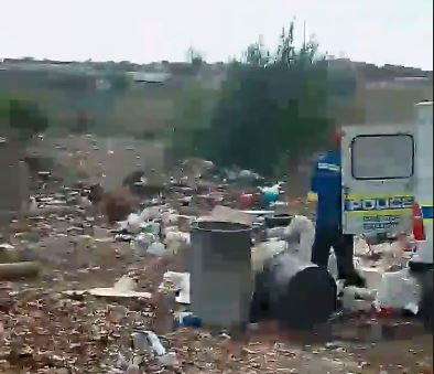 A video has emerged of a man emptying litter from the back of a police van into a heap of rubbish.