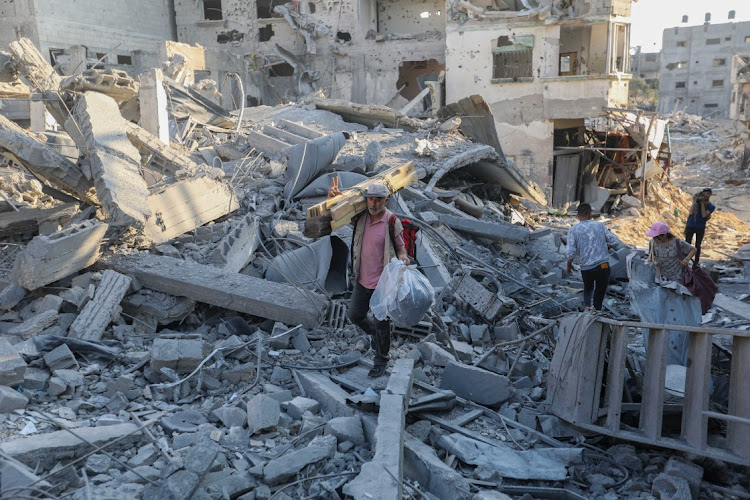 People inspect damage and remove items from their homes following Israeli airstrikes on April 07, 2024 in Khan Yunis, Gaza.