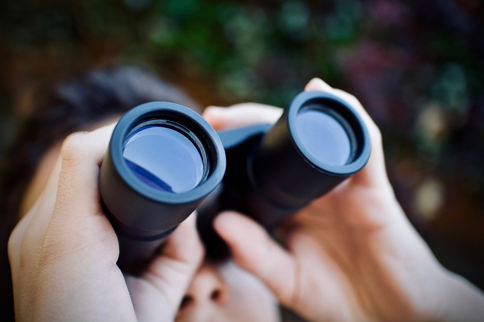 man looking through a pair of binoculars