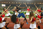 Usain Bolt of Jamaica struts his stuff alongside cheerleaders after victory in the men's 100m  at the IAAF Diamond League meeting in Monaco on Friday. 