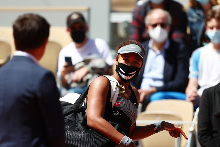 Naomi Osaka of Japan talks with Fabrice Santoro before being interviewed on court after winning her first-round match against Patricia Maria Tig of Romania in the French Open at Roland Garros in Paris on Sunday.