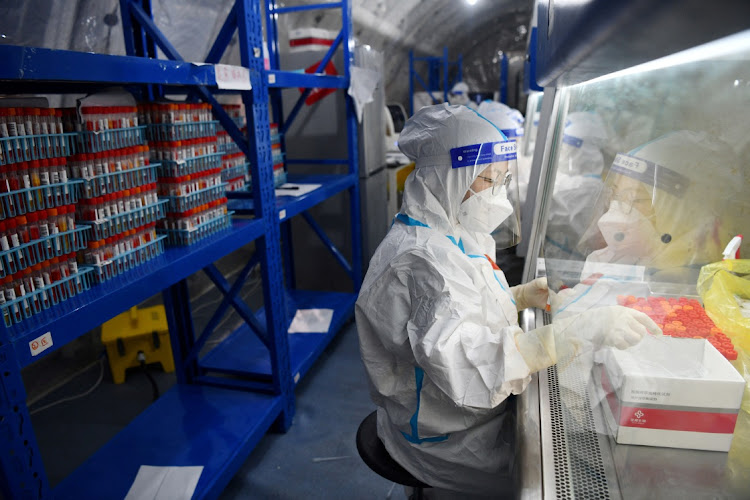 Staff members of Sichuan Provincial People's Hospital test nucleic acid samples inside a mobile laboratory set up at a sports centre in Chengdu, China, on September 4 2022. Picture: CNSPHOTO via REUTERS