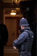 A police officer looks through the door to 10 Downing Street on April 12, 2022 in London, England. Scotland Yard have issued fifty fines in relation to parties and gatherings held inside Downing Street during Covid lockdown. Prime Minister Boris Johnson, his wife, Carrie Johnson and Chancellor Rishi Sunak have been issued with fixed penalty notices.   