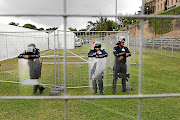 TESTING TIMES:   Guards wait  outside the giant tent on  UCT's sports fields where  students will be writing final exams.