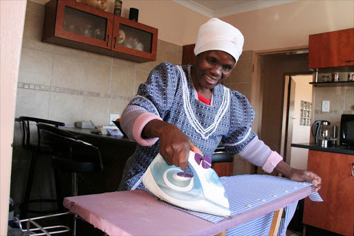 A domestic worker carries out ironing duties.