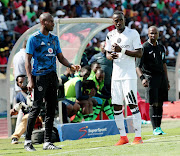 Orlando Pirates assistant coach Rhulani Mokwena prepares to brief Justin Shonga during a league match.