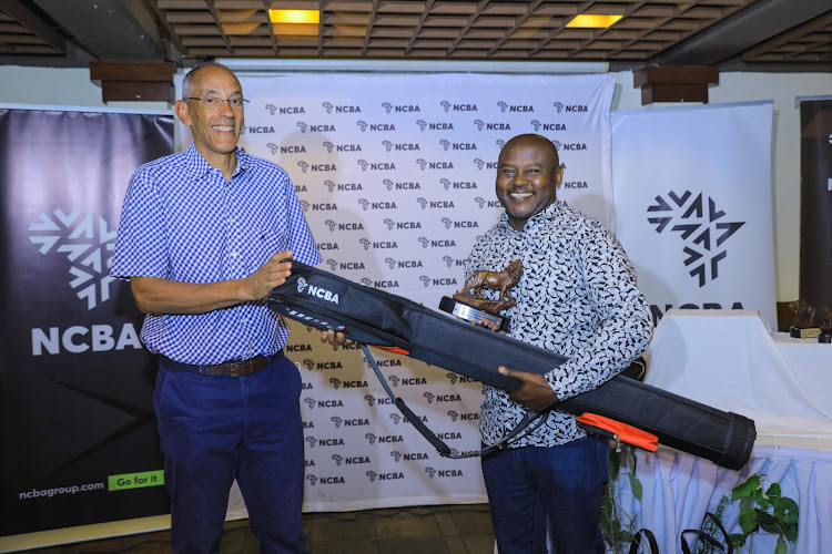 NCBA Group Chairman, James Ndegwa, presents the 2022 NCBA Golf Series Division One winner's trophy and prize to Great Rift Valley Lodge's Steven Njoroge during the club's leg