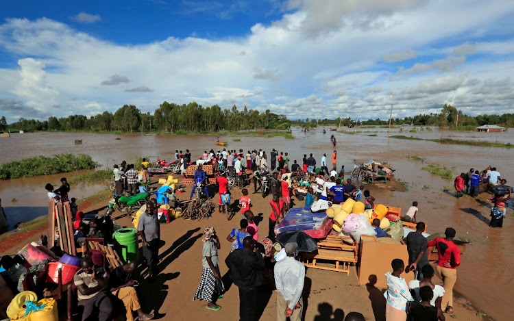 Residents gather on the safe grounds with their belongings after their homes were flooded as the River Nzoia burst its banks and due to heavy rainfall and the backflow from Lake Victoria.