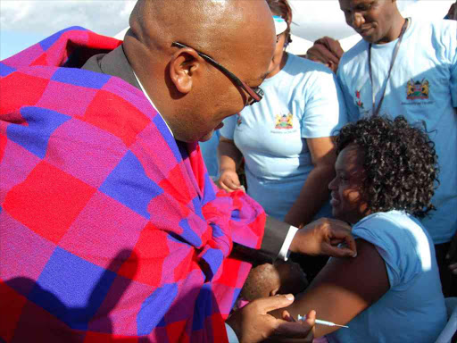 Principal Secretary for Health Dr. Nicholas Muraguri injects Tetanus vaccine to a mother during the national launch of Measles, Rubella and Tetanus vaccination in Narok County on May 17th,2016