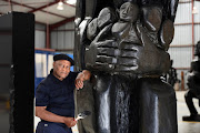 Pitika Ntuli, seen here posing with one of his large sculptures, has been celebrated as a Living Legend. 