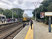 Anxious commuters stand on the tracks while waiting for a train.