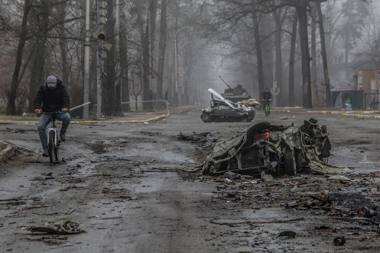 A local resident rides a bicycle past flattened civilian cars, as Russia's attack on Ukraine continues, on a street in the town of Bucha, in Kyiv region, Ukraine April 1 2022. Picture: REUTERS/OLEKSANDR RATUSHNIAK.