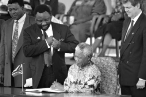 HISTORIC: Cyril Ramaphosa watches Nelson Mandela sign the South African constitution at Sharpeville. Mandela was concerned about the ghost of tribalism. PHOTO: Robert Botha