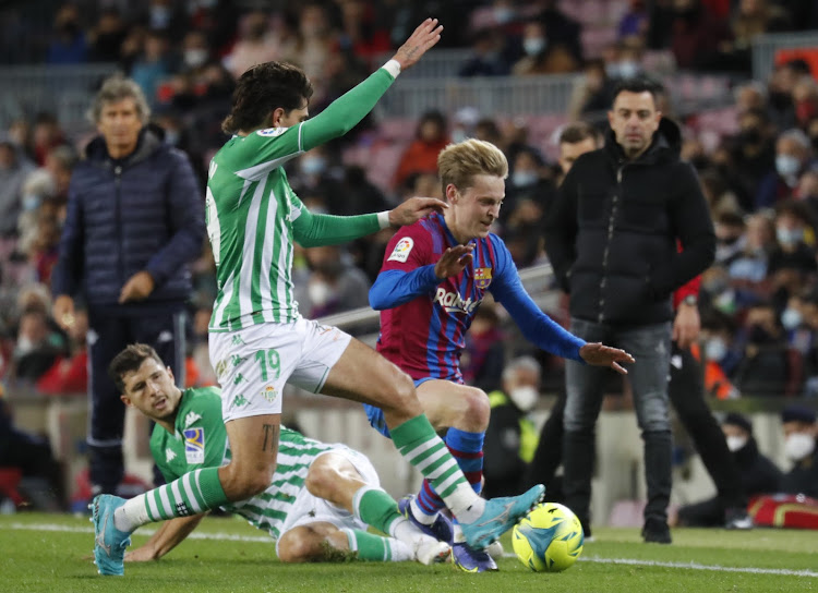 Barcelona manager Xavi Hernandez looks on as Frenkie de Jong is tackled by Real Betis' Hector Bellerin