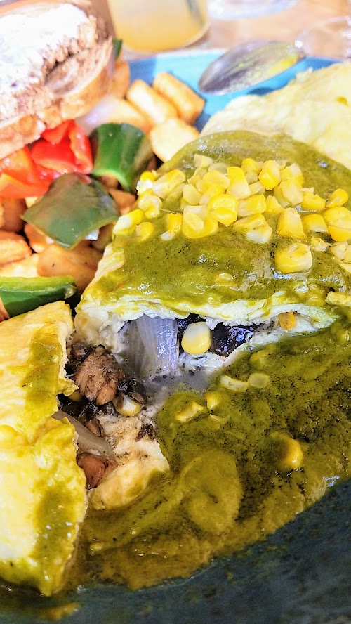 Alto Bajo Omelette a la Poblano includes three egg omelette, cheese, corn, huitlacoche, local mushrooms, poblano cream sauce, breakfast potatoes, and choice of wheat or rye toast or English muffin