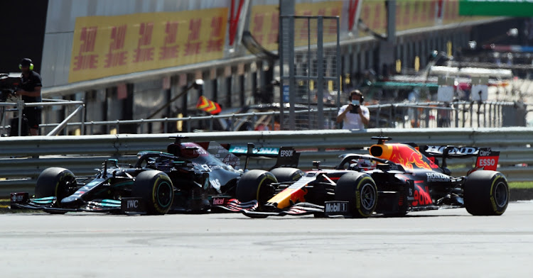 Red Bull's Max Verstappen, right, and Mercedes' Lewis Hamilton go side-by-side during the F1 British Grand Prix at Silverstone Circuit on July 18, 2021