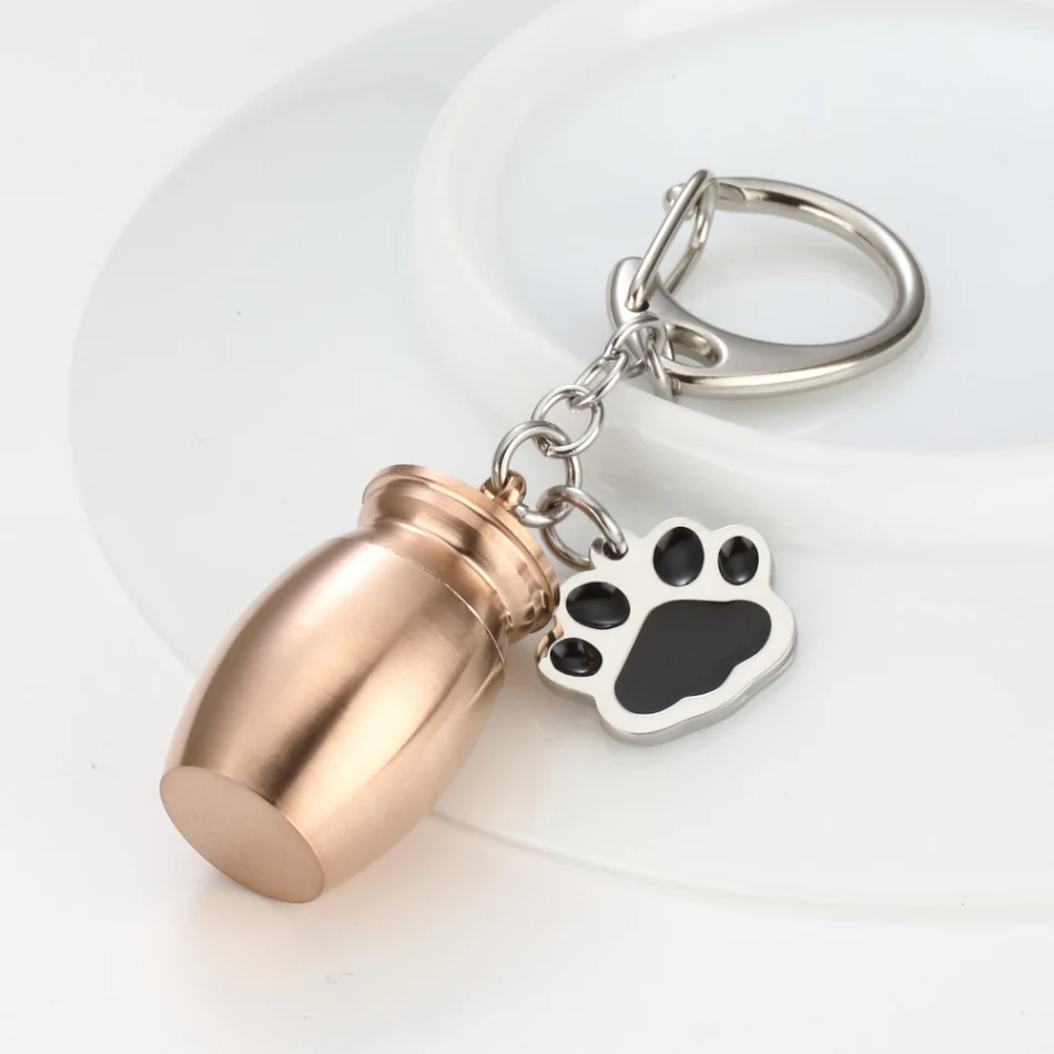 Parfumbottle sleutelhanger met oliedruppel en hondenpoot. Draag je favoriete geur altijd bij je, perfect voor hondenliefhebbers.
