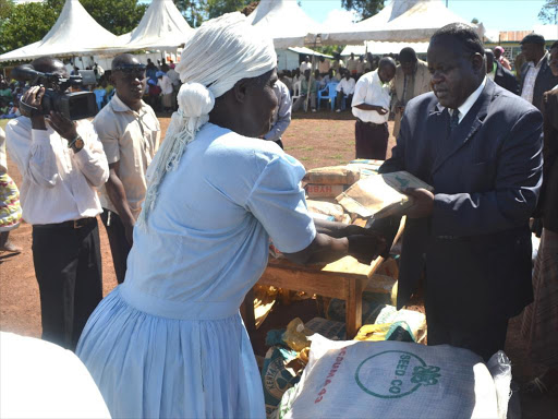 Governor Cyprian Awiti distributes seeds to residents of Gongo inRangwe sub county on April 20,2015. He said the government hasstarted giving assorted seeds to farmers across the County to helpboost food production.