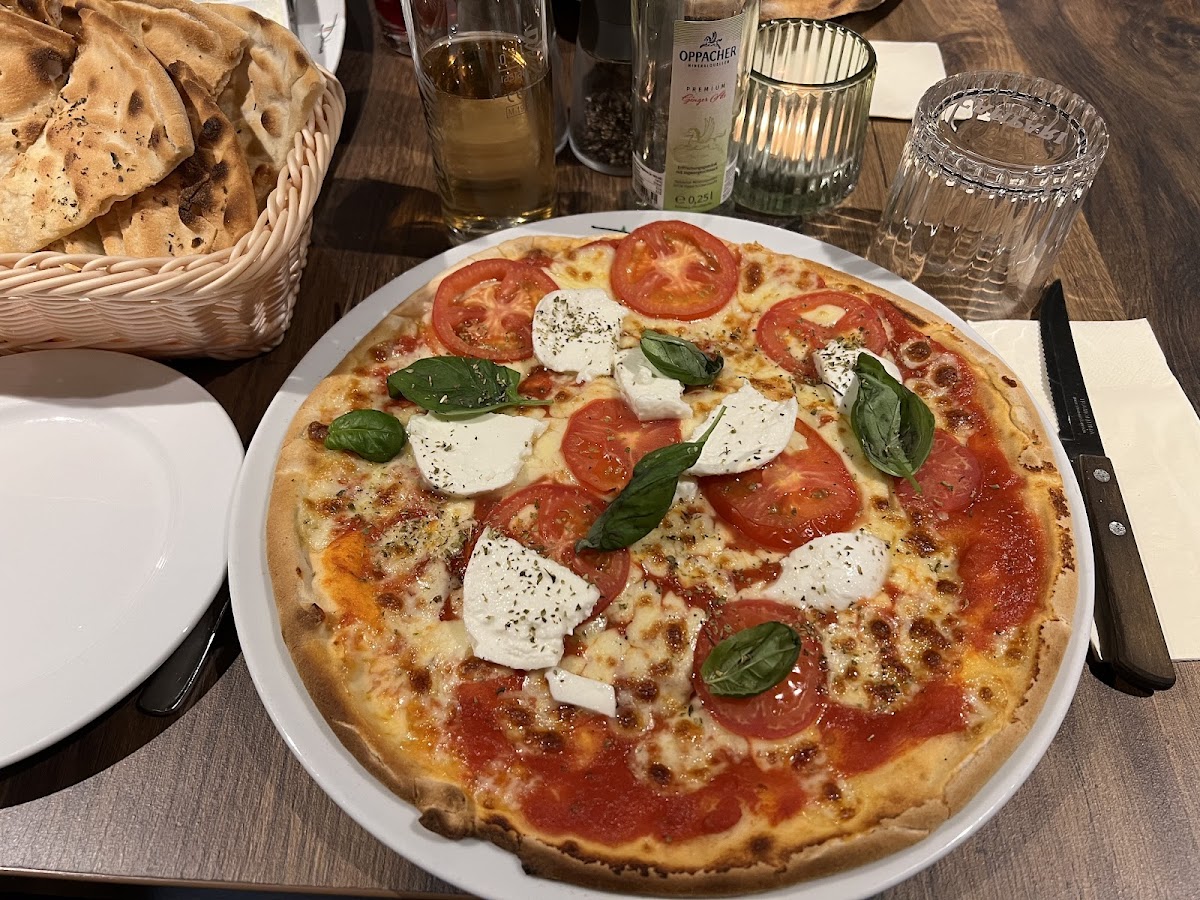 Pizza mit Büffelmozarella, Tomaten, Basilikum