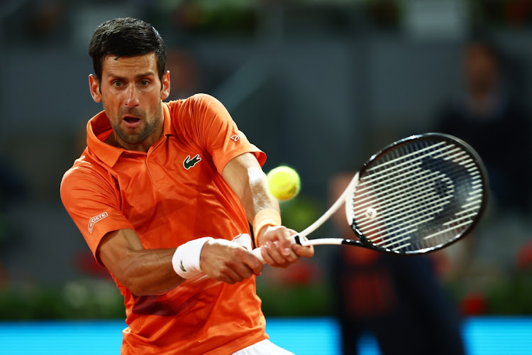 Novak Djokovic of Serbia plays a backhand in his second round match against Gael Monfils of France during day six of the Madrid Open at La Caja Magica on May 3, 2022