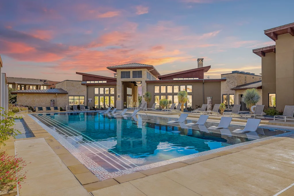 Bridge at Steiner Ranch's resort-style pool with sundeck featuring lounge chairs