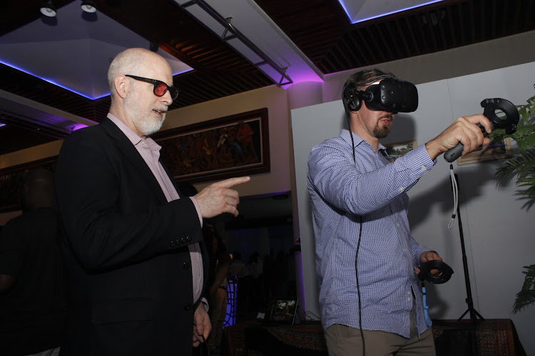 Immersive Reality Architect Brian First instructs Haanu Liinakoski how to use a Virtual Reality Experience