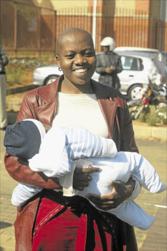 FLASHBACK: Gabaza Ngobeni, with her baby, walks out of the Randburg Magistrate's Court in 2005 after a maintenance case against UDM leader Bantu Holomisa. PHOTO: SYDNEY SESHIBEDI