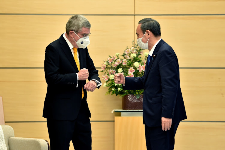 Japan's Prime Minister Yoshihide Suga (right) greets International Olympic Committee (IOC) president Thomas Bach during their meeting in Tokyo on November 16, 2020.