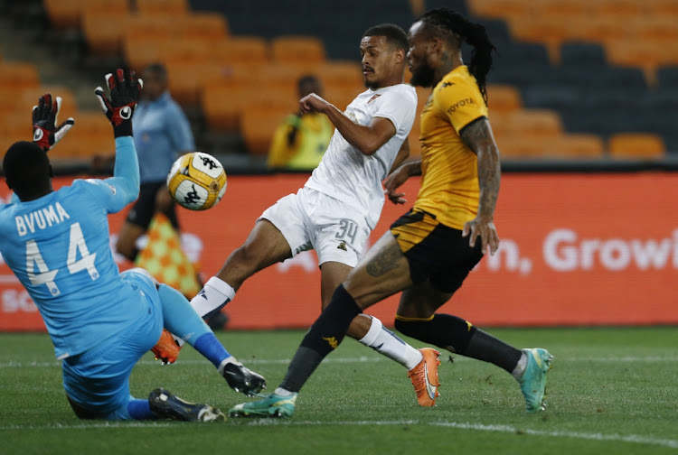 Devin Titus of Stellenbosch FC scores past Kaizer Chiefs goalkeeper Bruce Bvuma under the challenge of Edmilson Dove in the DStv Premiership match at FNB Stadium in Johannesburg on Tuesday night.