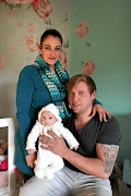 Kyle Wileman and Angelique Wells with their one-month-old daughter  Aurora, who tested positive for Covid but survived. 