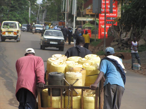 Water vendors pull a cart full of water jerricans. FILE