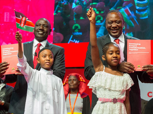 President Uhuru Kenyatta and Deputy President William Ruto with youngsters Lexy and Abubakar during the launch of the Jubilee Manifesto at the Kasarani Indoor Arena in Nairobi. Photo/PSCU