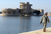 A US soldier walks past the Al-Faw palace on November 7, 2011, formerly owned by executed Iraqi leader Saddam Hussein and located in the Camp Victory complex in Baghdad.