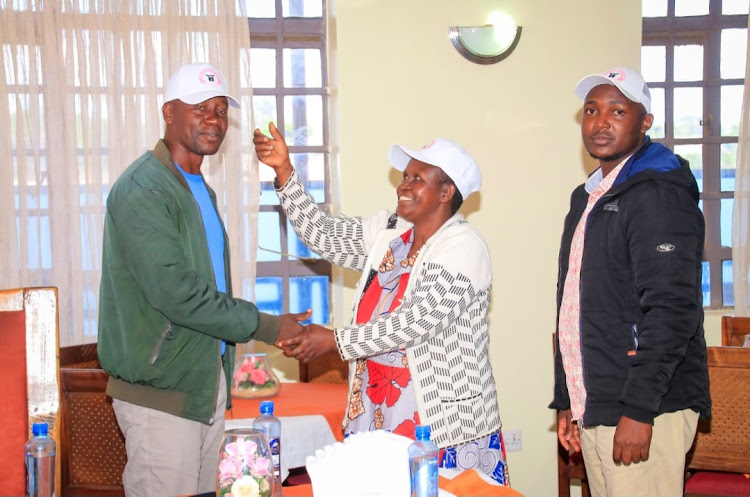 Entrust Pioneer Party official Lemayian Seleina (right) welcome new members during a function in Narok town.