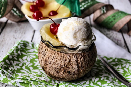 A scoop of pina colada sherbet in a coconut.