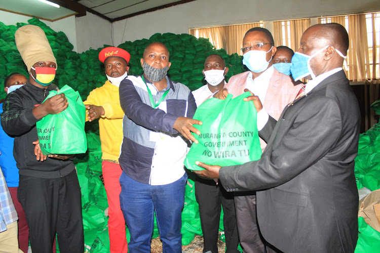 Murang'a governor issuing foodstuffs to representatives of matatu saccos and bar owners association last Friday.