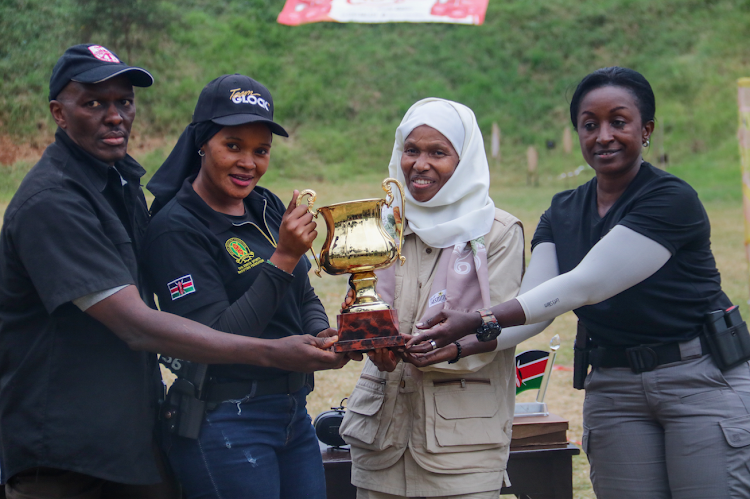 KDF shooter Irene Ndunda (2ND L) receives her trophy from Assistant Chief of Defence Forces Major General Fatuma Ahmed (2ND R), flanked by IPSC chairman Memba Muriuki(L) and Kenya Women Sports Shooting Club chair Pauline Munyi.