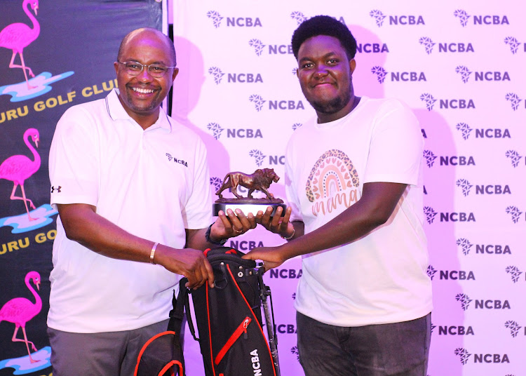 Twenty-year-old Kenneth Muraya (R) receives his Division One winner's trophy from Tirus Mwithiga, NCBA Group Director for Retail Banking, during the Nakuru leg last month