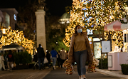 A shopper wearing a face protective mask walks by Christmas decorations at The Grove shopping center during a partial lockdown amid the outbreak of the coronavirus disease, in Los Angeles, California, US on December 7 2020. 
