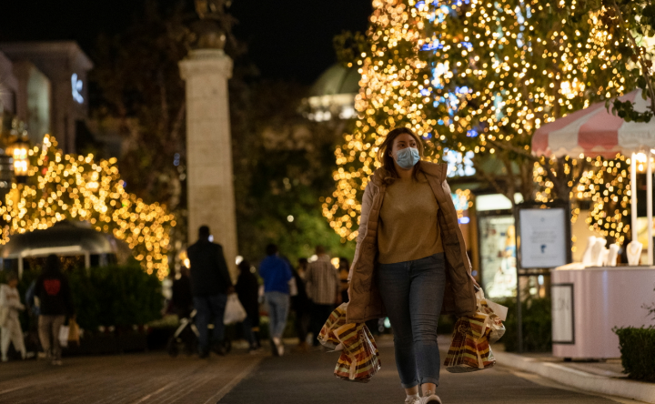 A shopper wearing a face protective mask walks by Christmas decorations at The Grove shopping center during a partial lockdown amid the outbreak of the coronavirus disease, in Los Angeles, California, US on December 7 2020.