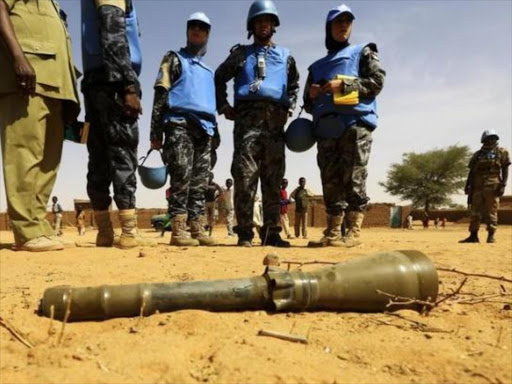 Peace keepers from the United Nations Hybrid Operation in Darfur (UNAMID) look at an RPG-7 projectile that was found at the Al-Abassi camp for internally displaced persons. Photo/REUTERS