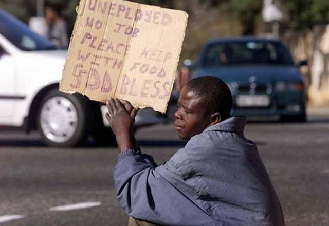 An unemployed young South African pleads for money or food at a street corner